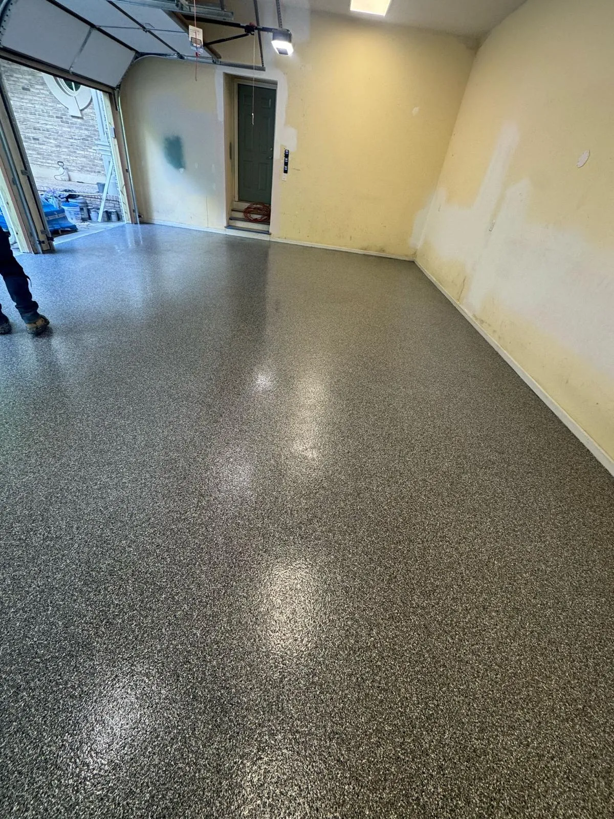 Grey decorative flake floor in an open warehouse with a clean coved perimeter